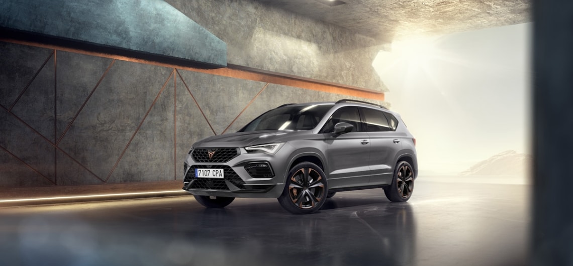 Vue avant de la CUPRA Ateca INICIO avec son extérieur accrocheur en Graphite Grey devant un décor architectural.