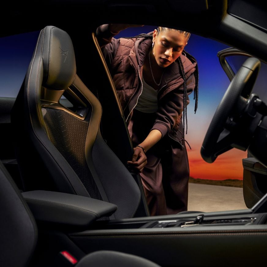 Una donna accanto a una CUPRA grigia