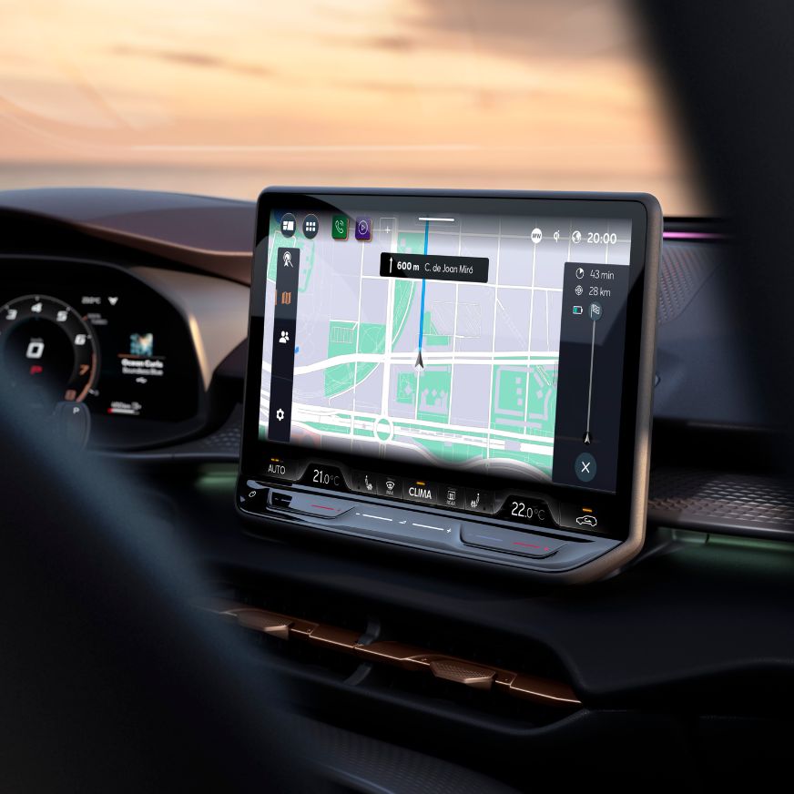 Una donna davanti a una CUPRA Ateca grigia con trench coat giallo