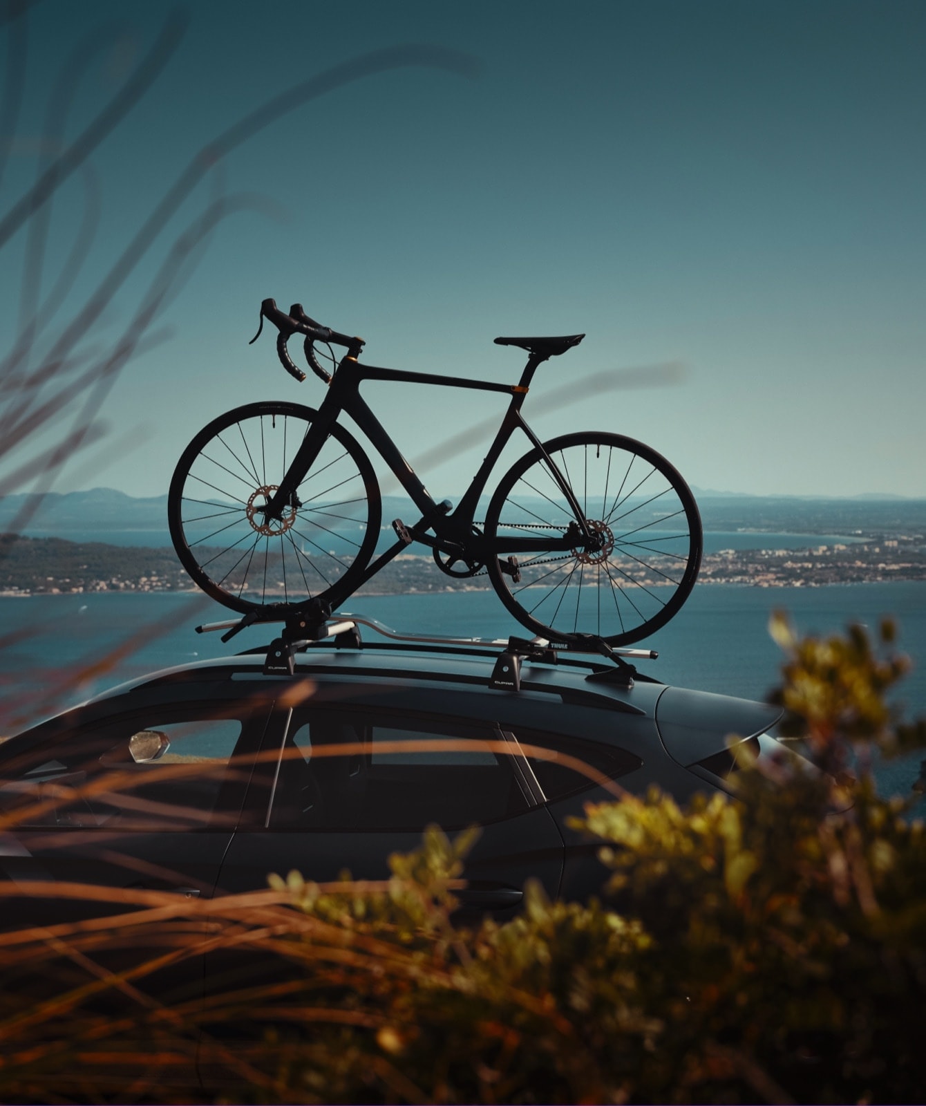 bike attached to the cupra formentors roof rack with blue sky backdrop.