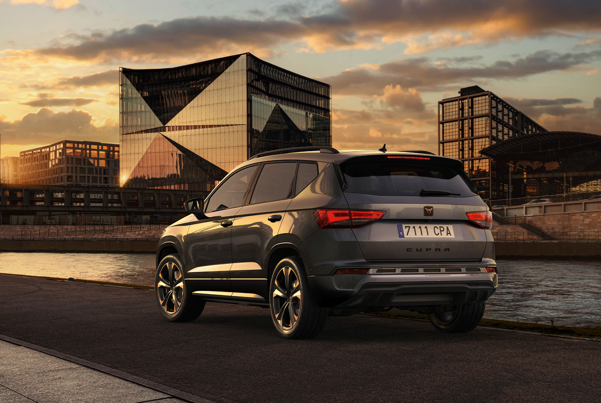 Vue arrière du SUV CUPRA Ateca au coucher du soleil avec vue sur la calandre plus basse avec clapets d’air et le diffuseur arrière, qui soulignent tous deux le design extérieur.