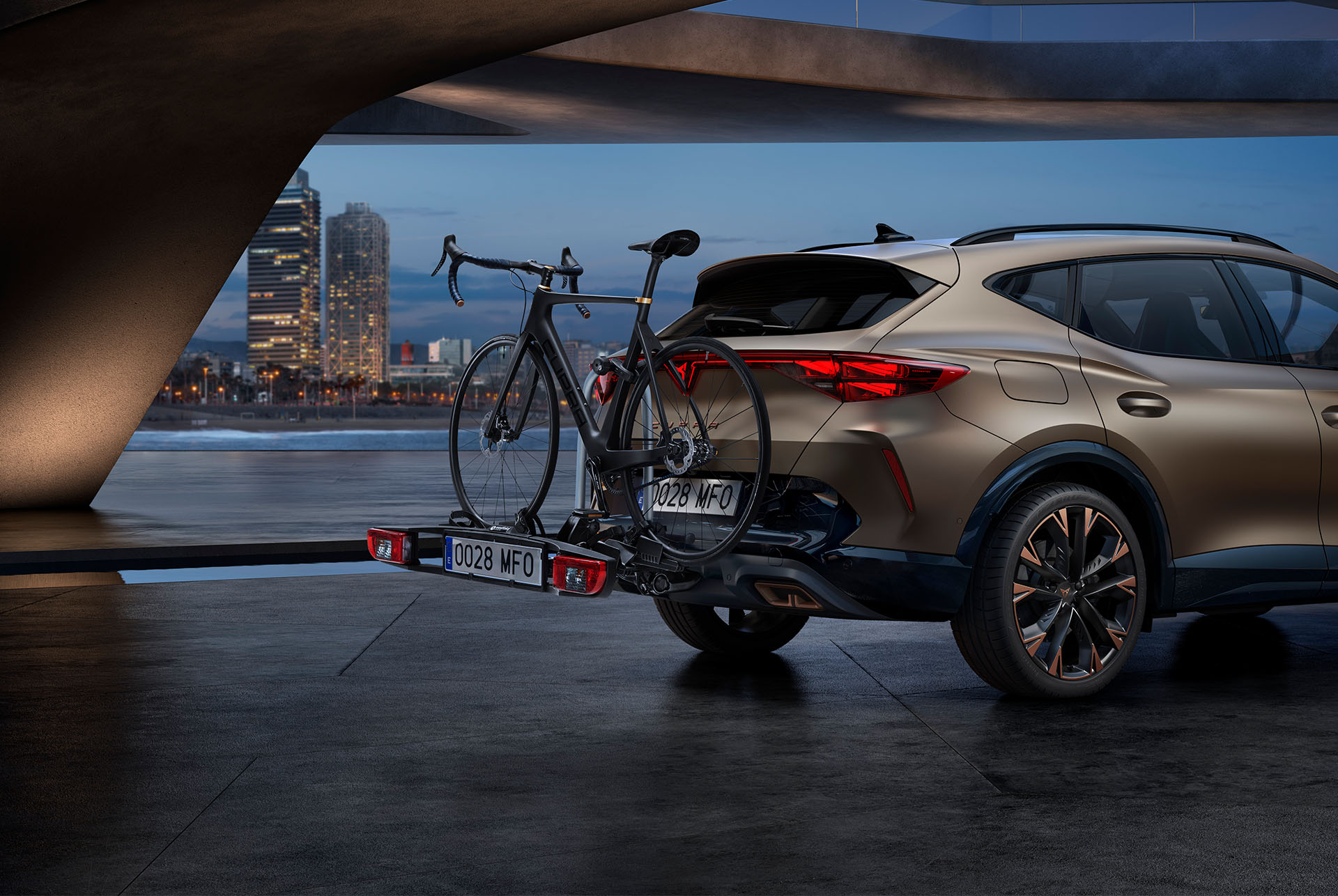 Accessoire de voiture CUPRA Formentor 2024 en bronze du nouveau siècle, porte-vélos arrière et de remorquage, avec la ligne d'horizon de la ville en arrière-plan.