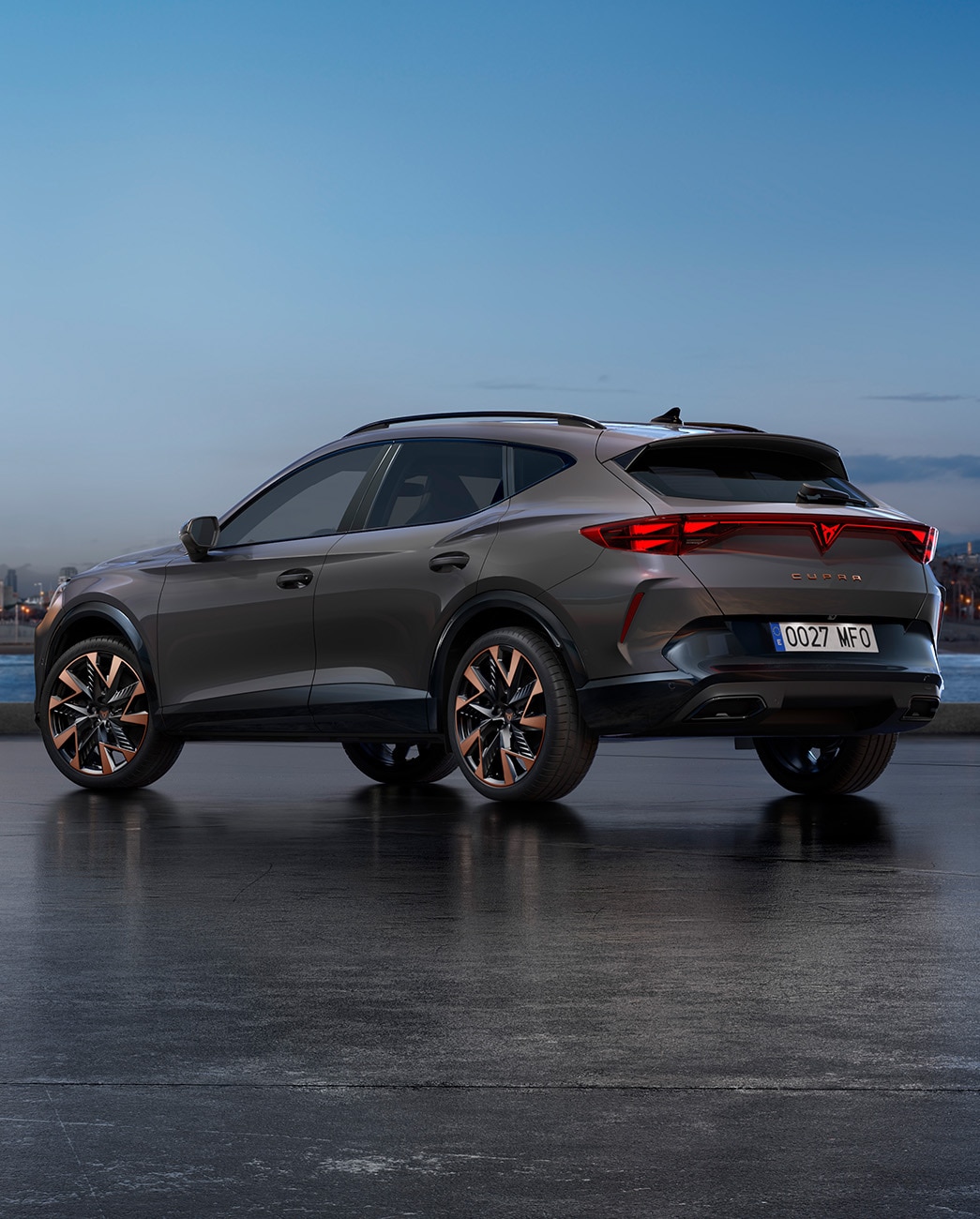 Ein neuer CUPRA Formentor 2024 CUV in Graphene Grey, parkiert an der Uferpromenade in der Dämmerung. Im Hintergrund die Silhouette der Stadt mit Hochhäusern und Palmen im Licht des sich zu Ende neigenden Tages. 