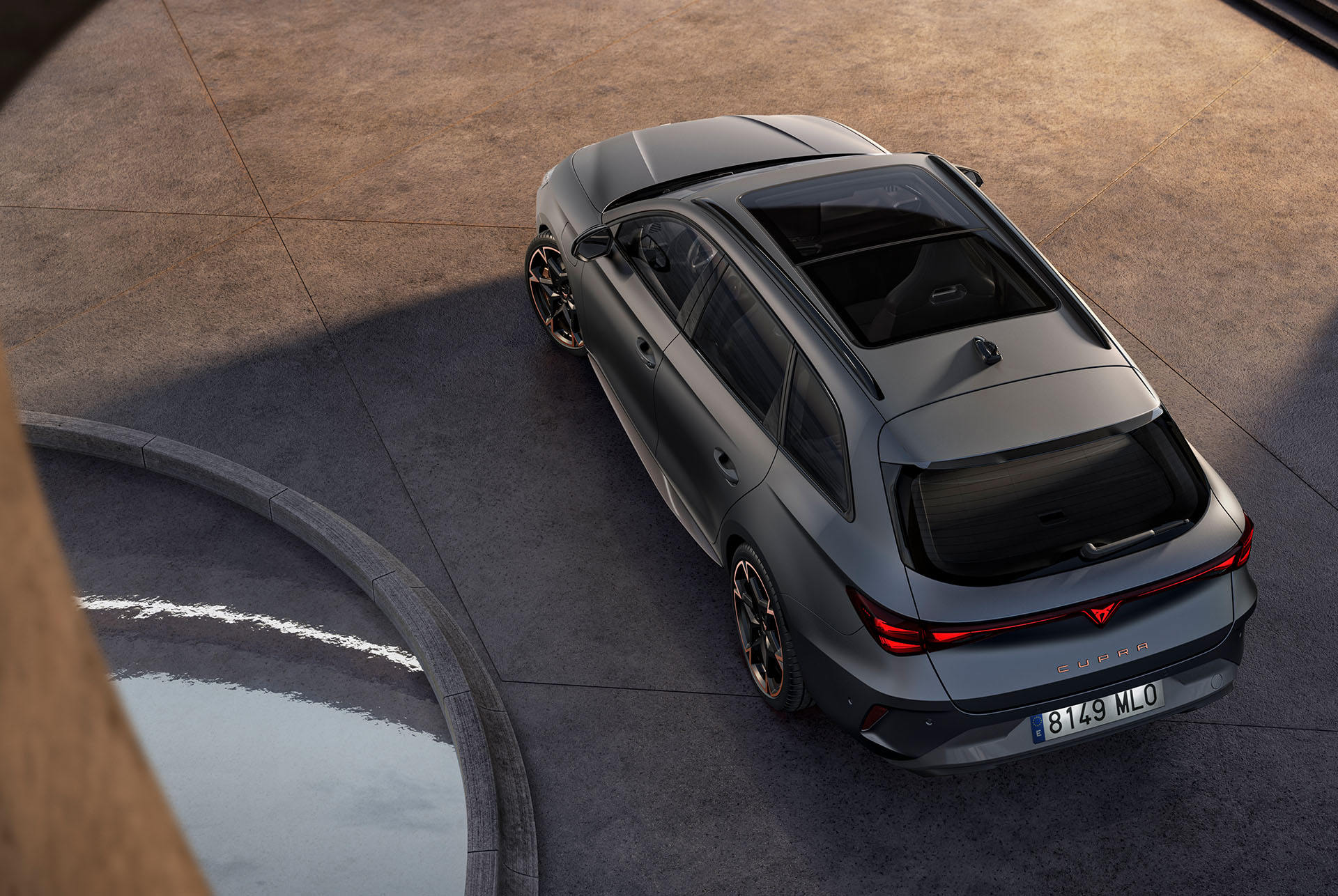 La technologie hybride de la nouvelle CUPRA Leon Sportstourer 2024, garée sur du béton, vue aérienne du toit ouvrant panoramique et hayon électrique