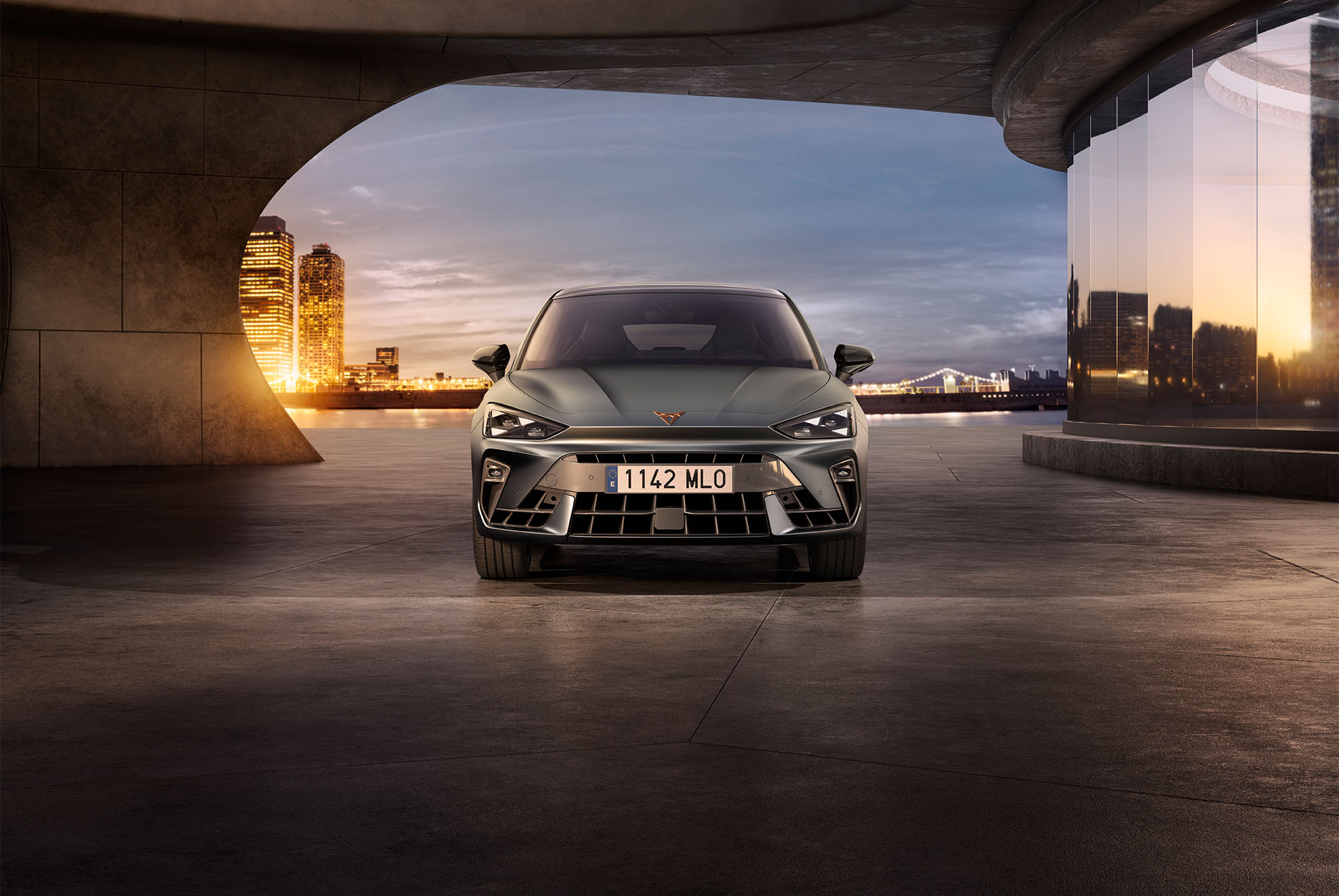 Modellversionen und Ausstattung des neuen CUPRA Leon 2024, Lufteinlässe, Dreiecksaugen-Scheinwerfer, Sonnenuntergang, Glasscheiben, Architektur und blauer Himmel.