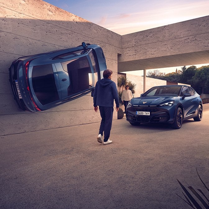 Surreale architektonische Szene mit einem blauen CUPRA-Auto, das vertikal an einer Betonmauer angebracht ist, neben einem anderen blauen Auto, das normal in einer Einfahrt geparkt ist, und einer Person, die sich auf den Eingang zubewegt.