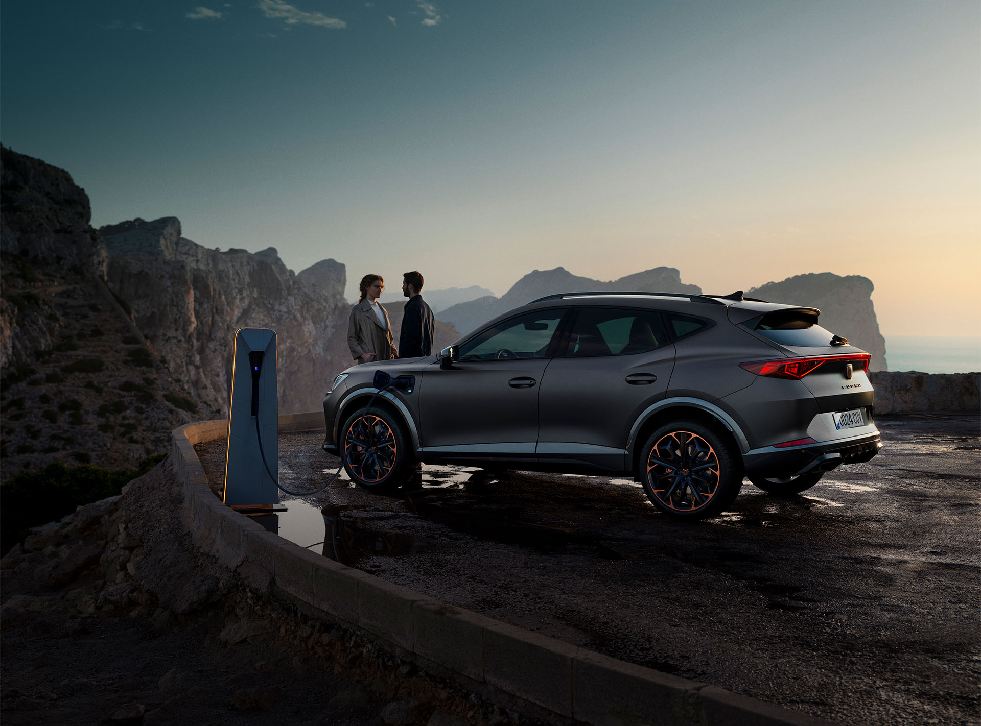 La CUPRA Formentor et un couple au coucher de soleil avec vue sur les montagnes