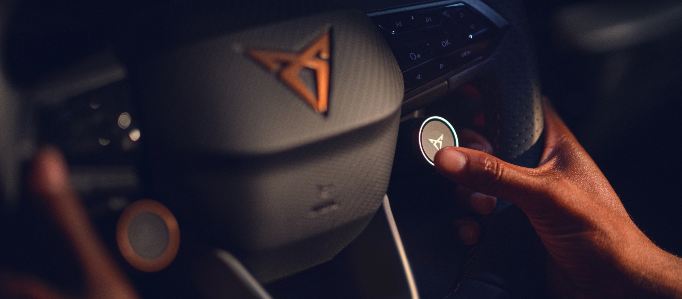 Cupra geborenes Lenkrad mit Satellitentasten und kupferfarbenem Akzent cupra Logo, Nahaufnahme im Firmenwagen.