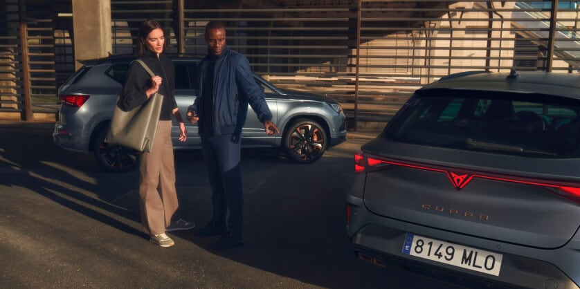 Zwei Personen im Parkhaus neben mehreren CUPRA Fahrzeugen stilvolle Firmenmobilität im urbanen Umfeld.