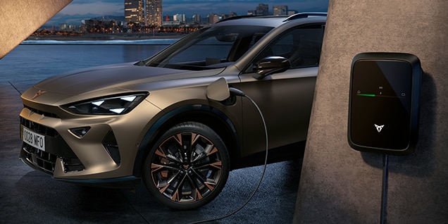 Jahrhundert bronzeelektrischer cupra formentor suv in eine EV-Ladebox mit einer Skyline der Stadt im Hintergrund eingesteckt