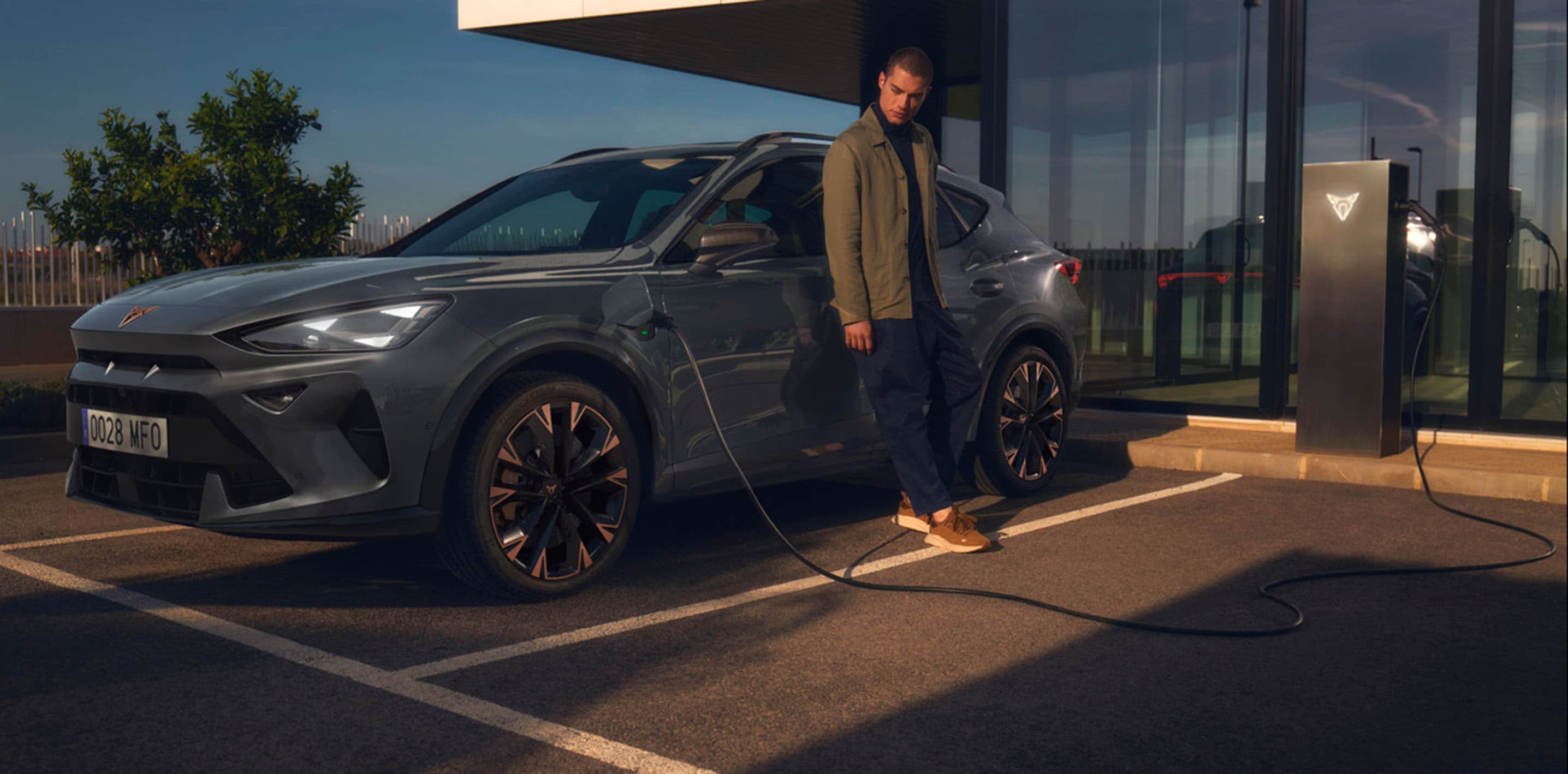magnetic tech grauer cupra formentor, der mit dem Mann draussen wartet, auflädt